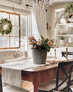 a dining room table with flowers in a bucket