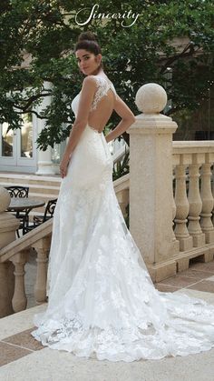 a woman in a wedding dress is standing on the stairs with her back to the camera