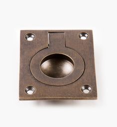 a square metal object with holes in the center on a white background, close up