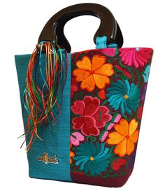 a colorful handbag with flowers and fringes on it's handle is shown