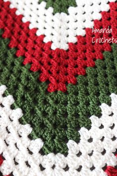 a crocheted blanket with red, white and green colors is shown in closeup