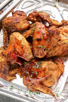 chicken wings with ketchup and parsley in a foil container