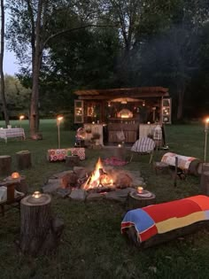 a fire pit surrounded by logs and candles