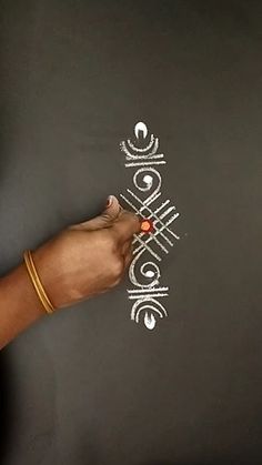 a person is writing on a blackboard with white letters and an orange bead