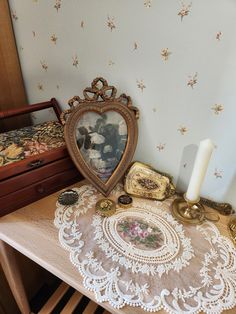 a table topped with a heart shaped mirror next to a candle