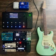 an electric guitar and other musical equipment on a wooden floor