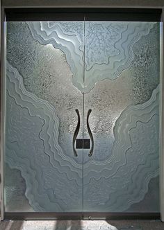 a glass door with an artistic design on the front and side panels that are designed to look like wavy lines