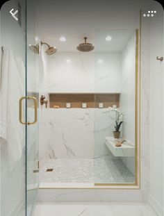 a bathroom with white marble and gold accents