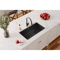 a kitchen counter with a sink and bowl of apples on the counter next to it