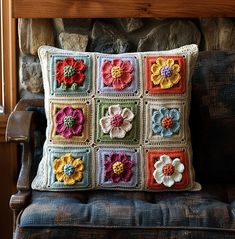 a crocheted flower pillow sitting on top of a chair next to a fireplace