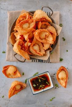 some fried food is on a plate with dipping sauce in the bowl next to it