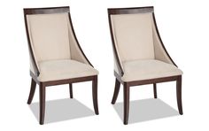 a pair of dining chairs with beige upholstered backrests and dark wood legs