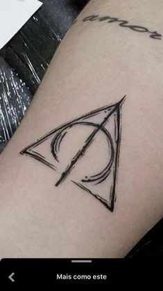 a harry potter symbol tattoo on the right arm and lower arm, with an arrow in the center