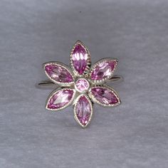 Our 14k white gold pink tourmaline birth flower ring is a birthstone ring & statement ring in one. This is a custom designed ring, which means it is one of a kind design. We love the floral theme in jewelry, as it is the ultimate in femininity, while being fun! Floral jewelry always makes me smile. We used 6 Marquise shaped gemstones for the petals and the center is a 3mm round gemstone. All gems are bezel set for stone security. The metal outlining the petals is given detail by hand. Let us mak Pink Sapphire Ring In Sterling Silver, Pink Sapphire Sterling Silver Ring, Fine Jewelry Pink Sapphire Ring In Sterling Silver, Pink Flower Shaped Sterling Silver Ring, Pink Flower Sterling Silver Ring, Pink Flower-shaped Sterling Silver Ring, Pink Tourmaline Sapphire Ring Gift, Sterling Silver Flower Ring In Pink, Pink Flower Rings In Fine Jewelry Style