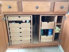 an open cabinet with drawers and bottles in it