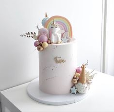 there is a cake decorated with unicorns and stars on the top, along with other decorations