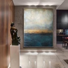 a large painting hanging on the wall in a living room next to a dining room table