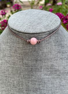 SEE ALL PHOTOS! One stone Rhodonite choker made on a rustic brown leather. **THESE STONES VARY FROM LIGHT PINK TO DARK PINK**IF YOU HAVE A PREFERENCE PLEASE ADD NOTE TO SELLER OR MESSAGE ME. RIGHT NOW I HAVE MORE OF THEM IN LIGHT PINK.  Natural Rhodonite stone, size 10mm.  Premium leather is super soft and comfortable. Color is a rustic brown. Can be made with black leather also.  End caps and lobster clasp are all stainless steel and will not tarnish or peel.  Please message me with any questio Spiritual Brown Choker As Gift, Spiritual Brown Choker Gift, Adjustable Brown Choker As A Gift, Pink Rhodonite, Leather Chokers, Rustic Brown, Choker Necklaces, Organza Bags, Dark Pink