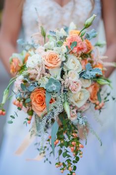 a bridal holding a bouquet of flowers and greenery