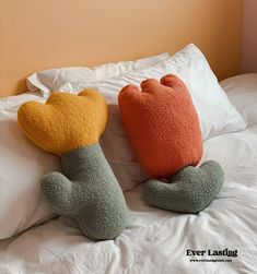 two stuffed animals laying on top of a bed next to each other in the shape of legs