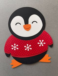 a penguin is wearing a red sweater with snowflakes on it's chest