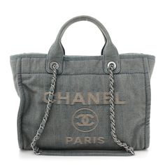 This is an authentic CHANEL Denim Small Deauville Tote in Light Blue. This lovely bag is crafted of fine blue denim with a Chanel advertisement logo. The shoulder bag features rolled denim top handles and matte silver chain link leather threaded shoulder straps. The bag has an open top and a blue fabric interior with zipper and patch pockets and a removable pouch. Tote Bag Chanel, Blue Denim Top, Chanel Denim, Chanel Tote Bag, Chanel Tote, Oversized Bag, Chanel Logo, Versace Bags, Leather Thread