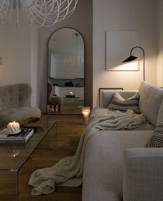 a living room filled with furniture and a large mirror on the wall above it's coffee table