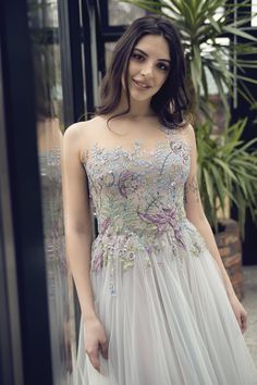 a woman in a white dress posing for the camera