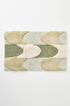 an area rug with various shapes and colors on it, including green, beige, grey and white