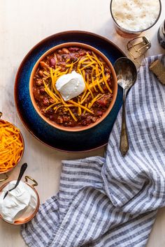 a bowl of chili with cheese and sour cream