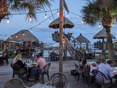 people are sitting at tables on the dock