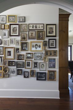 a wall with many framed pictures on it