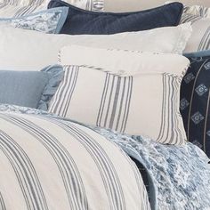 a bed with blue and white striped pillows