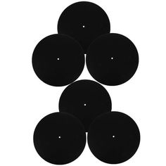 four black discs sitting on top of each other in the middle of a white background