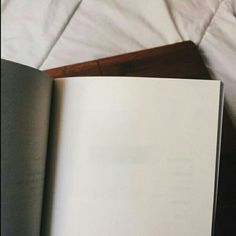 an open book sitting on top of a bed