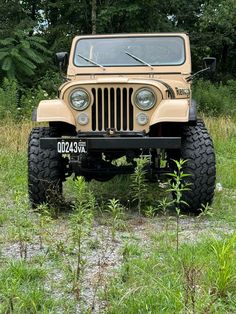 an old jeep is parked in the grass