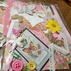 a table topped with lots of different types of buttons and paper crafts on top of each other