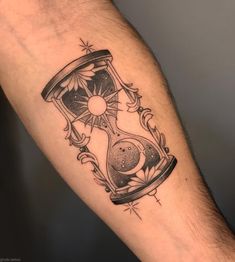 a man's arm with an hourglass tattoo on it