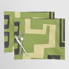 two placemats with forks on them sitting next to each other