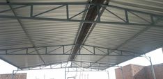 the inside of a building that is covered with metal sheeting and steel beams,