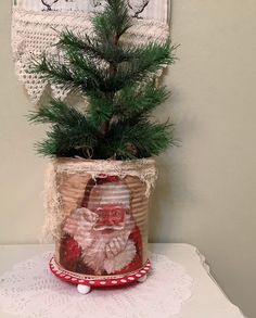 a potted plant with a santa clause on it sitting next to a doily