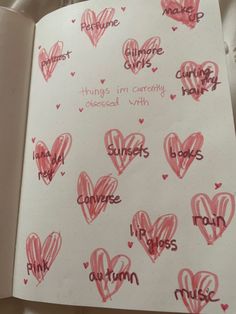 an open notebook with writing and hearts on it