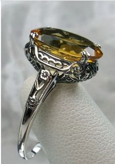 Here we have an Edwardian reproduction ring in sterling silver filigree with a lovely Natural/genuine (4ct to 5ct) Yellow Citrine gemstone solitaire. This full cut oval gem is 14mm in length and 10mm in width. This ring also sits 7mm off the finger. The inside of the band is marked 925 for solid sterling. Notice the beautiful leaf design of the silver filigree setting and etched band. Yellow Citrine Ring, Edwardian Ring, Yellow Citrine, Citrine Ring, Sterling Silver Filigree, Natural Citrine, Citrine Gemstone, Filigree Ring, Silver Filigree