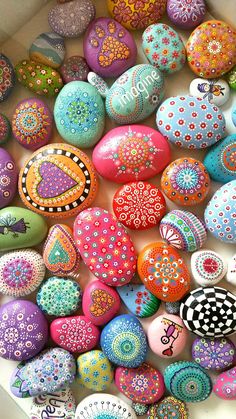 there are many colorful painted rocks in the box with name written on them and designs