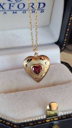 This is a 14KT gold filled garnet heart pendant necklace. Hallmarks: RC 14KGF Chain measures 19" Penadant measures 5/8" x .5" Weighs: does not measure on scale All measurements are approximate.  Condition: Good vintage condition. Normal wear associated age. A few light surface scratches and slight discoloration. Please see photos. Sold as is. Priced accordingly.  Please look over carefully and inspect any and all photos. Our shop is committed to fully disclosing all items' conditions and history Cute Heart Necklace, Heart Shaped 14k Stamped Jewelry For Valentine's Day, Valentine's Day Round Heart Locket Necklace, Valentine's Day Heart Locket Necklace, Red Locket Necklace For Valentine's Day, Valentine's Day Red Locket Necklaces, Garnet Heart, Heart Shaped Necklace, Garnet Necklace