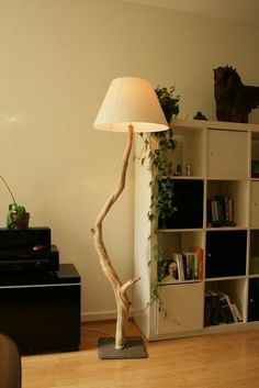 a living room with a lamp and bookshelf in the corner, next to a bookcase