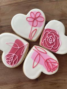 four decorated cookies in the shape of hearts