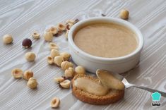 a bowl of peanut butter next to some nuts