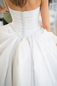 the back of a woman's white wedding dress