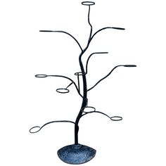 a metal tree with four circles on it's branches and two leaves in the center